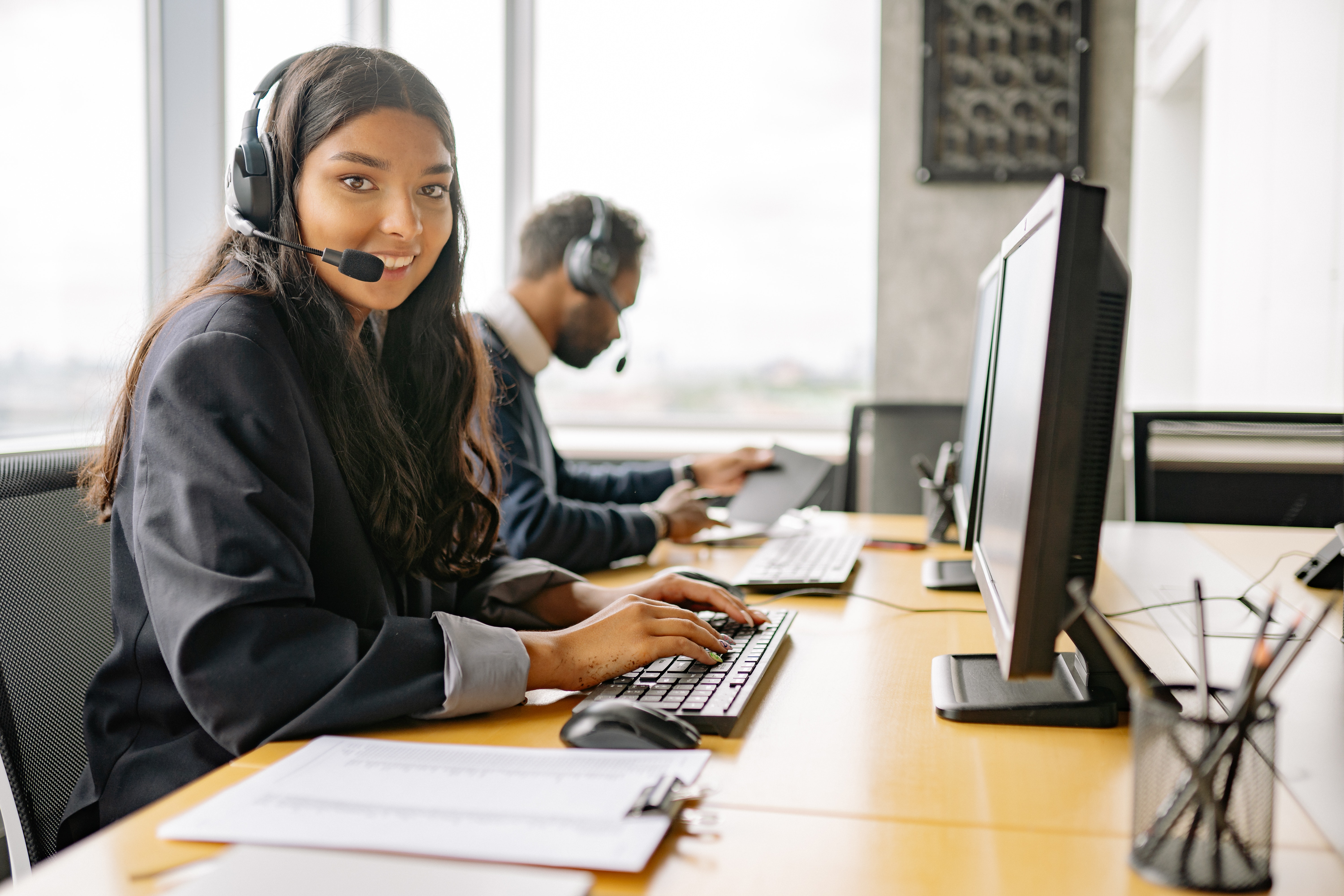 Smiling Woman Sitting in Front of Computer Screen