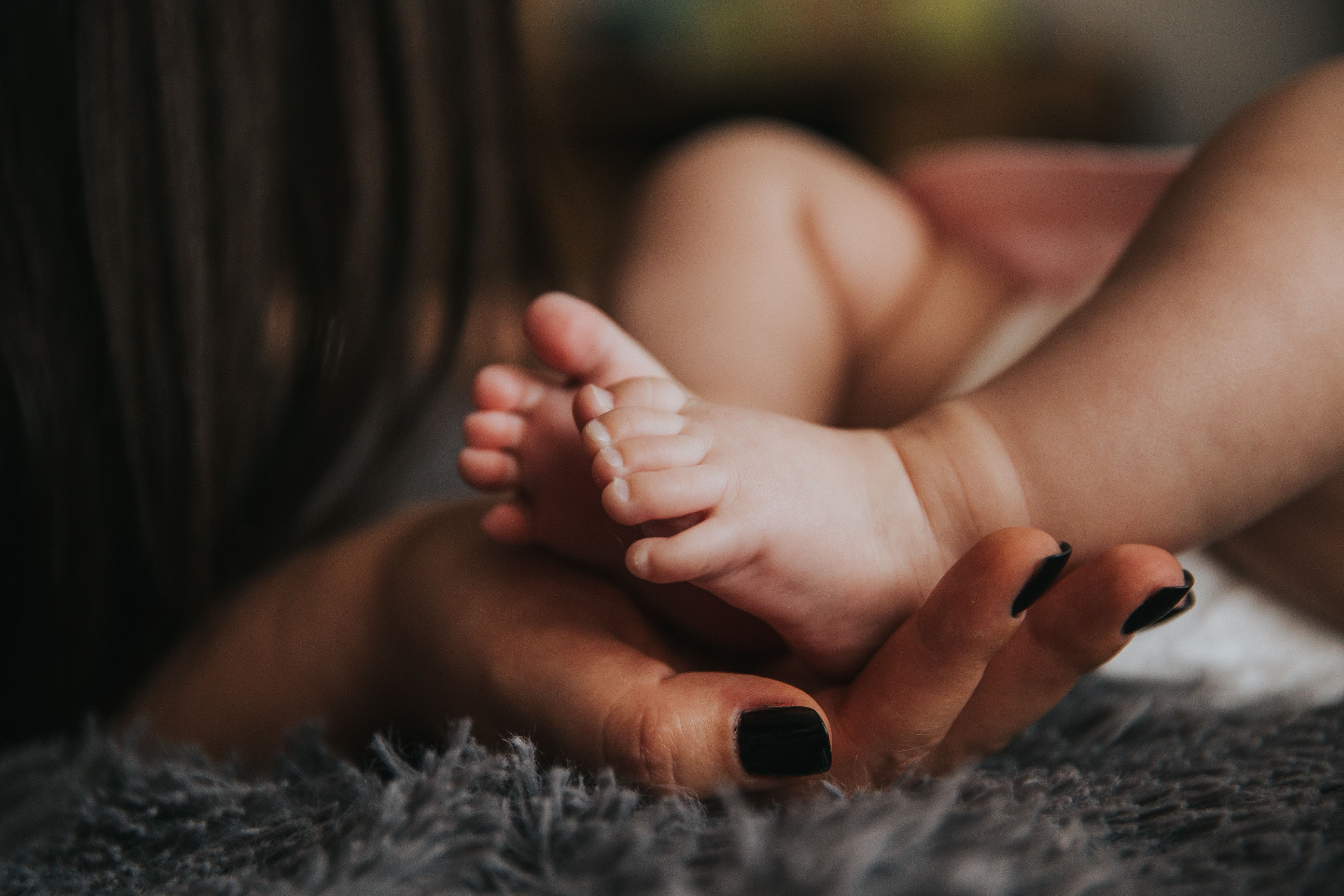 Mothers hands and baby feet