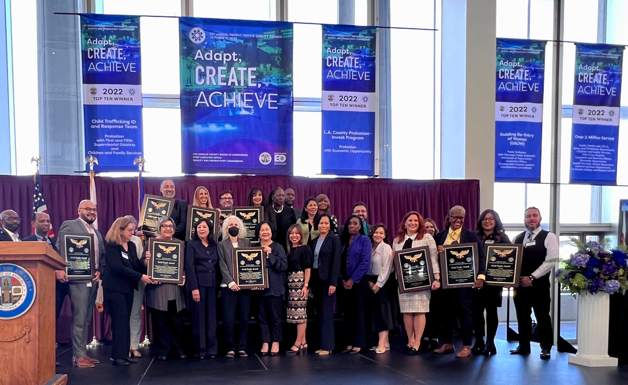 Community members and community organizations standing and holding Golden Eagle Award